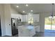 Modern kitchen features stainless steel appliances, white cabinets, and a large center island at 16487 Sw 55Th, Ocala, FL 34473