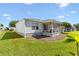 Well-maintained backyard featuring a screened in patio, lush lawn, and mature landscaping at 17076 Se 96Th Chapelwood Cir, The Villages, FL 32162