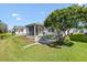 Well-maintained backyard featuring a screened in patio, lush lawn, and mature landscaping at 17076 Se 96Th Chapelwood Cir, The Villages, FL 32162