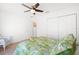 Bright bedroom featuring a ceiling fan, and a stylish bed with a tropical floral comforter at 17076 Se 96Th Chapelwood Cir, The Villages, FL 32162