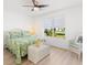 Bright bedroom featuring a ceiling fan, natural light, and a stylish wicker bed and matching side chair at 17076 Se 96Th Chapelwood Cir, The Villages, FL 32162