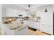 Bright kitchen features white cabinets, a modern backsplash, stainless appliances, and a marbled countertop at 17076 Se 96Th Chapelwood Cir, The Villages, FL 32162