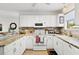 Bright kitchen features white cabinets, stainless appliances, and a marbled countertop at 17076 Se 96Th Chapelwood Cir, The Villages, FL 32162