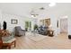 The open living area features a ceiling fan, sliding door to lanai, and neutral decor at 17076 Se 96Th Chapelwood Cir, The Villages, FL 32162
