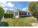 Private backyard featuring a charming trellis, well-maintained lawn, and neat landscaping for a relaxing outdoor experience at 1709 Betrillo Ct, The Villages, FL 32162