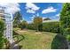 Private backyard featuring a charming trellis, well-maintained lawn, and neat landscaping for a relaxing outdoor experience at 1709 Betrillo Ct, The Villages, FL 32162