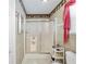 Cozy bathroom featuring a glass-enclosed shower, patterned wallpaper, and charming decor at 1709 Betrillo Ct, The Villages, FL 32162