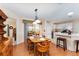 Charming dining room open to kitchen with wooden table and view of sunroom at 1709 Betrillo Ct, The Villages, FL 32162