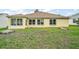 Exterior view of backyard with bright stucco, multiple windows, and enclosed sunroom at 17238 Se 94Th Coults Cir, The Villages, FL 32162