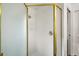 Updated shower featuring glass door, white tile, and gold trim at 17238 Se 94Th Coults Cir, The Villages, FL 32162