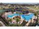 Aerial view of a community pool surrounded by palm trees, with a clubhouse and seating at 17386 Blazing Star Cir, Clermont, FL 34714