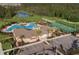 Aerial view of community center with pool, tennis courts, and lush landscaping at 17386 Blazing Star Cir, Clermont, FL 34714