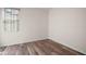 Bedroom featuring wood flooring, neutral walls, and a window with stylish blinds at 17386 Blazing Star Cir, Clermont, FL 34714