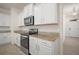 Bright kitchen featuring stainless steel appliances, granite counters and white cabinets at 17386 Blazing Star Cir, Clermont, FL 34714