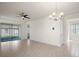 Bright living room with tile flooring, modern ceiling fan, neutral paint, and sliding door access to lanai at 17386 Blazing Star Cir, Clermont, FL 34714