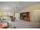 Spacious living room featuring plush carpet, a ceiling fan, and a large entertainment center at 1902 Del Norte Dr, Lady Lake, FL 32159