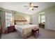 Bright bedroom with plush carpet, ceiling fan, and natural light from the windows enhance the relaxing space at 20 Ginger Cir, Leesburg, FL 34748