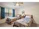 Cozy bedroom with twin beds, a ceiling fan, and comfortable decor offer a relaxing and inviting space at 20 Ginger Cir, Leesburg, FL 34748