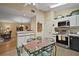 Eat-in kitchen featuring stainless steel appliances, white cabinetry, and hardwood floors at 20 Ginger Cir, Leesburg, FL 34748