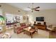 Spacious living room with vaulted ceiling, ceiling fan, hardwood floors and large TV at 20 Ginger Cir, Leesburg, FL 34748