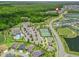 An aerial view showcases a community, highlighting the pool, tennis courts, and neighborhood amenities at 2006 Oppenheimer Ct, The Villages, FL 34762