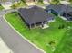 An aerial view showcases the home's backyard, including a screened patio and outdoor grilling area at 2006 Oppenheimer Ct, The Villages, FL 34762