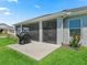 A spacious screened-in patio extends from the home, complemented by a BBQ area and a lush lawn at 2006 Oppenheimer Ct, The Villages, FL 34762