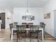 The dining room has neutral walls, wood-look floors, and a modern light fixture, adjacent to the kitchen at 2006 Oppenheimer Ct, The Villages, FL 34762