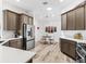 Spacious kitchen featuring stainless steel appliances, stylish cabinets, white countertops, and an adjacent dining area at 2006 Oppenheimer Ct, The Villages, FL 34762