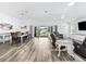 Open-concept living room and dining area with wood-look floors leading to sliding glass doors and outdoor space at 2006 Oppenheimer Ct, The Villages, FL 34762