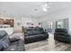 Open-concept living area featuring wood-look floors, leather seating, and views of the kitchen and dining area at 2006 Oppenheimer Ct, The Villages, FL 34762