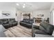 Spacious living area with wood-look floors, leather seating, and an open layout to the kitchen and dining room at 2006 Oppenheimer Ct, The Villages, FL 34762