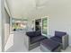 Comfortable patio with wicker seating, ceiling fans, and views of the outdoor dining area and backyard at 2006 Oppenheimer Ct, The Villages, FL 34762