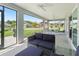 Spacious screened-in patio with dark wicker furniture and views of the well-manicured backyard at 2006 Oppenheimer Ct, The Villages, FL 34762