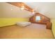 Spacious attic bedroom with carpeted floors, wood paneled walls, exposed beams and natural light at 2112 Robie Ave, Mount Dora, FL 32757