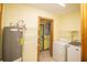 Well-equipped laundry room featuring a water heater, shelving, and modern washing machine and dryer at 2112 Robie Ave, Mount Dora, FL 32757