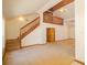 Open-concept living area with wooden staircase, high ceilings, and neutral carpet, creating a warm and inviting atmosphere at 2112 Robie Ave, Mount Dora, FL 32757
