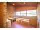 Office space featuring built in desks, wood paneling, a large window, and brick wall at 2112 Robie Ave, Mount Dora, FL 32757