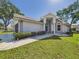 Charming single-story home featuring a manicured lawn, decorative rock landscaping, and a welcoming entryway at 21707 Queen Mary Ct, Leesburg, FL 34748