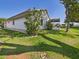 Exterior view showing a home's screened lanai, landscaped yard, and tidy outdoor appearance at 21707 Queen Mary Ct, Leesburg, FL 34748