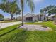 Beautiful home with a well-manicured lawn, charming landscaping, and an inviting facade at 21707 Queen Mary Ct, Leesburg, FL 34748