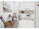 Cozy kitchen featuring white appliances and cabinets, a breakfast table, and light-colored tile flooring at 21707 Queen Mary Ct, Leesburg, FL 34748