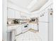Functional kitchen featuring white appliances and cabinets, complemented by light-colored tile flooring and good lighting at 21707 Queen Mary Ct, Leesburg, FL 34748