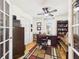 Inviting office space featuring hardwood floors, a ceiling fan, built in bookcase, and a large desk at 21707 Queen Mary Ct, Leesburg, FL 34748