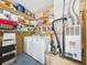 Well-organized utility room with washer, dryer, storage shelves, and essential home maintenance equipment at 21707 Queen Mary Ct, Leesburg, FL 34748