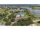 An aerial view of community with several tennis courts, a community pool, and a lake at 21815 Tartan St, Leesburg, FL 34748