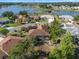 Beautiful aerial shot of a home with a screened-in patio, surrounded by mature trees and a tranquil lake in the community at 21815 Tartan St, Leesburg, FL 34748