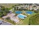 Aerial view of community amenities including a pool, tennis courts, clubhouse, and parking at 21815 Tartan St, Leesburg, FL 34748
