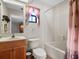 Bright bathroom featuring a vanity, toilet, and a tub with a shower at 21815 Tartan St, Leesburg, FL 34748
