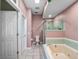 Bathroom with a combination tub and shower, toilet, and a pastel color scheme at 21815 Tartan St, Leesburg, FL 34748